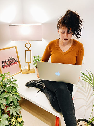 Girl on laptop with lamp and picture frame behind her