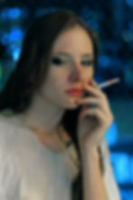 Mujer fumando con fondo azul.