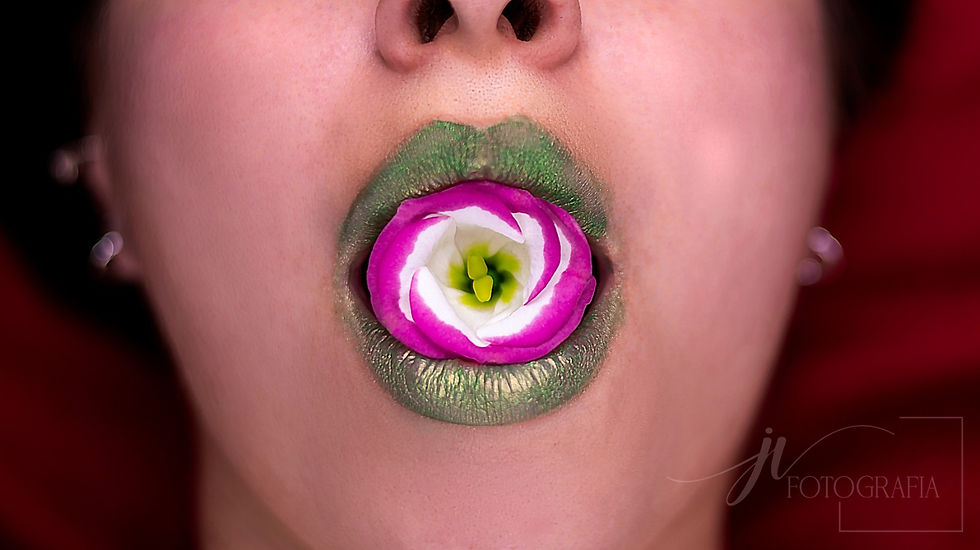 Boca de mulher com batom verde e flor na boca