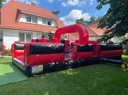 Czerwono-czarna dmuchana przeszkoda, zabawa na świeżym powietrzu