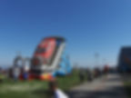 Duża dmuchana zjeżdżalnia tor wyścigowy. Czerwone auto. Dmuchaniec dla dzieci.