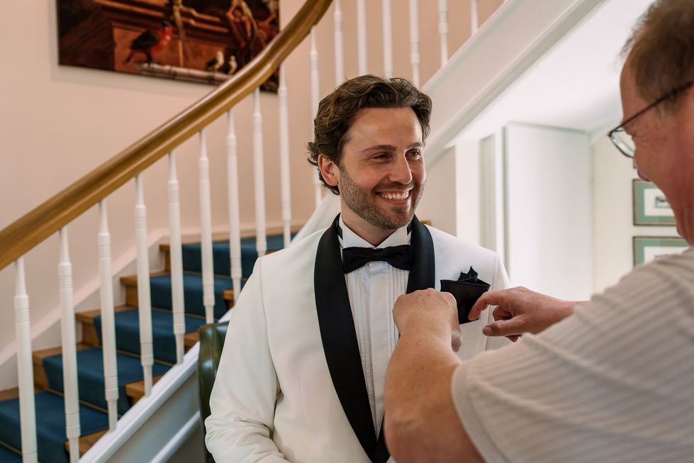 Pascal im weißen Hochzeitsanzug beim Ankleiden