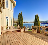 Sunny spacious walkout deck of luxurious Mediterranean style waterfront home overlooking p