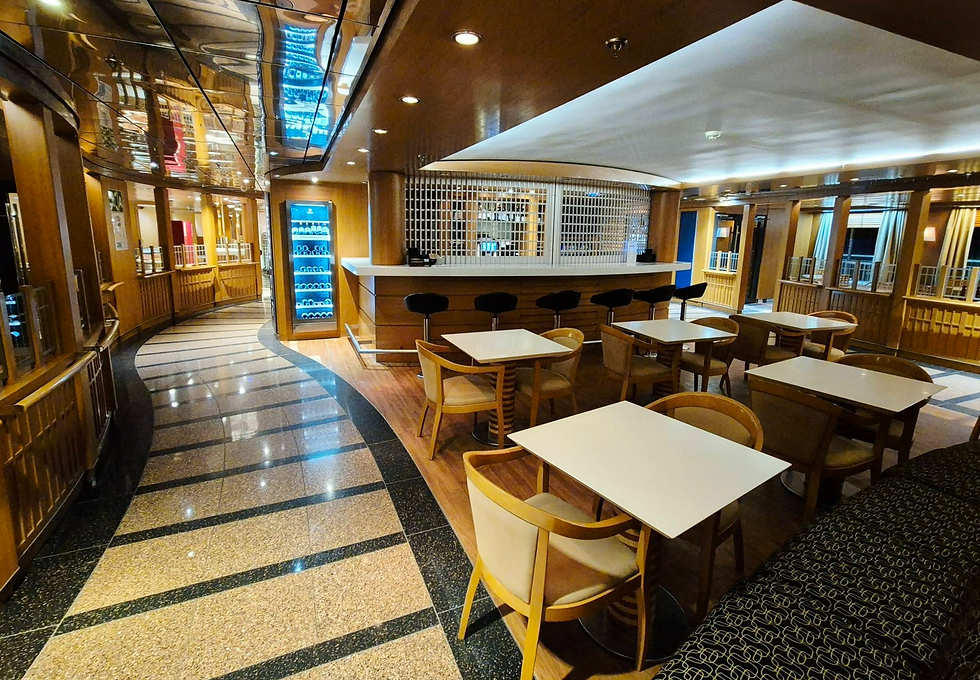 Empty modern Hibernia Line ship lounge with white tables, bar stools, glossy wood panels, and blue-lit cooler.