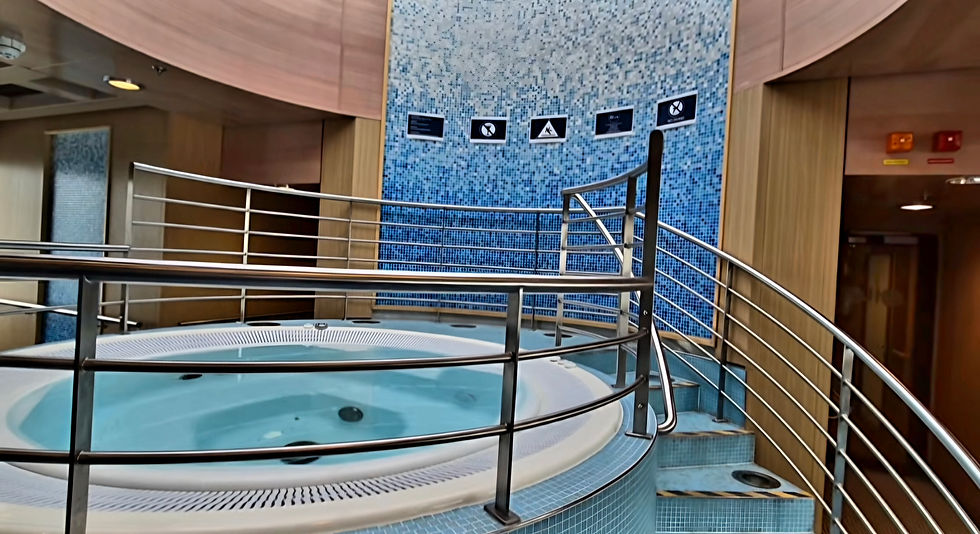 Indoor spa hot tub aboard Hibernia Line ferry with metal railings and blue mosaic wall, calm empty wellness area with warning signs above the pool