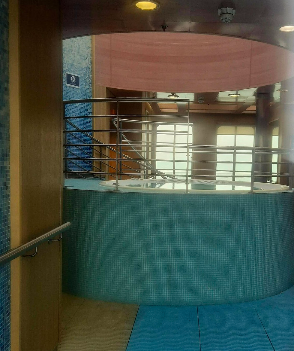 Empty indoor spa pool aboard a Hibernia Line ferry with turquoise mosaic tiles, metal railings, soft light, and a no-diving sign on the wall.