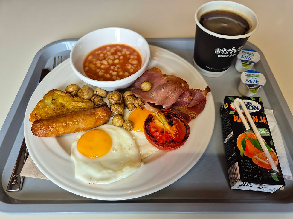 Breakfast tray with eggs, bacon, sausage, beans, mushrooms, tomato, coffee, juice and milk pots on a grey tray aboard a Hibernia Line ferry