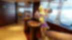 Cartoon rabbit statue on a Moby Lines ferry holds mop heads, resembling pom-poms. Elegant wooden décor, with a visible exit sign.