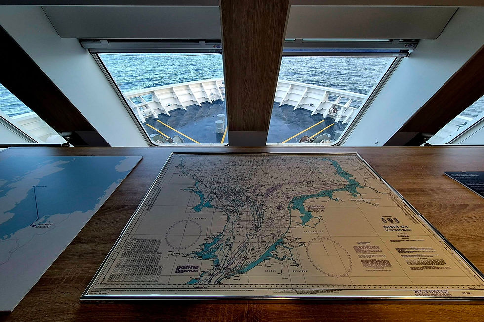 DFDS Ship chart table with North Sea map and bow view through windows to open ocean; label reads North Sea Southern Sheet.