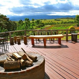outdoor wood lanai with seating and a firepit and a beautiful view of Ngorongoro Crater
