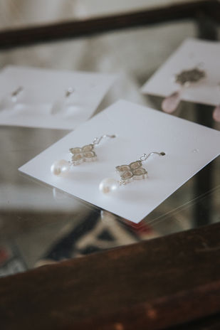 Sterling Silver Pearl earrings feature an intricate Moroccan-inspired pattern with ivory pearls dangling from solid silver earrings. More earrings in the background.  Designed by Cheree Edwards Fine Jewellery 
