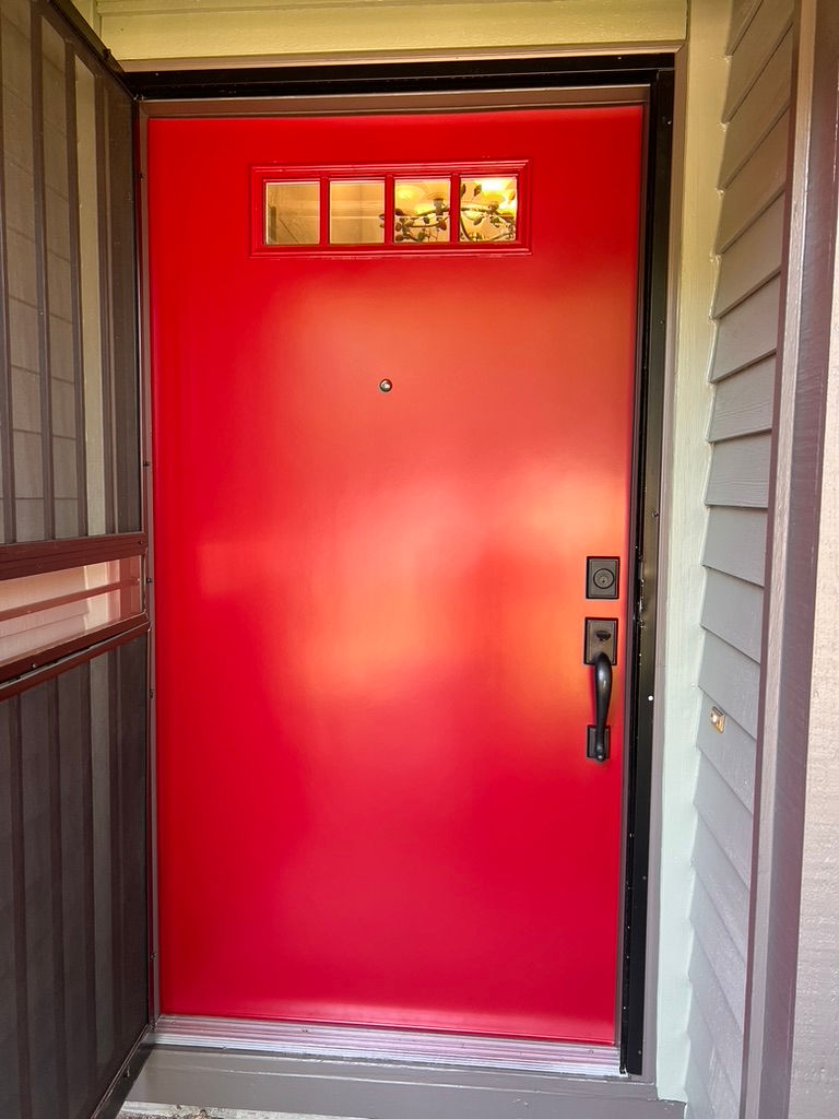 Final result of a professional exterior door painting project in Tigard; featuring a vibrant Passion Red spray finish with a modern, factory-smooth appearance by Amazing Painting & Renovation.