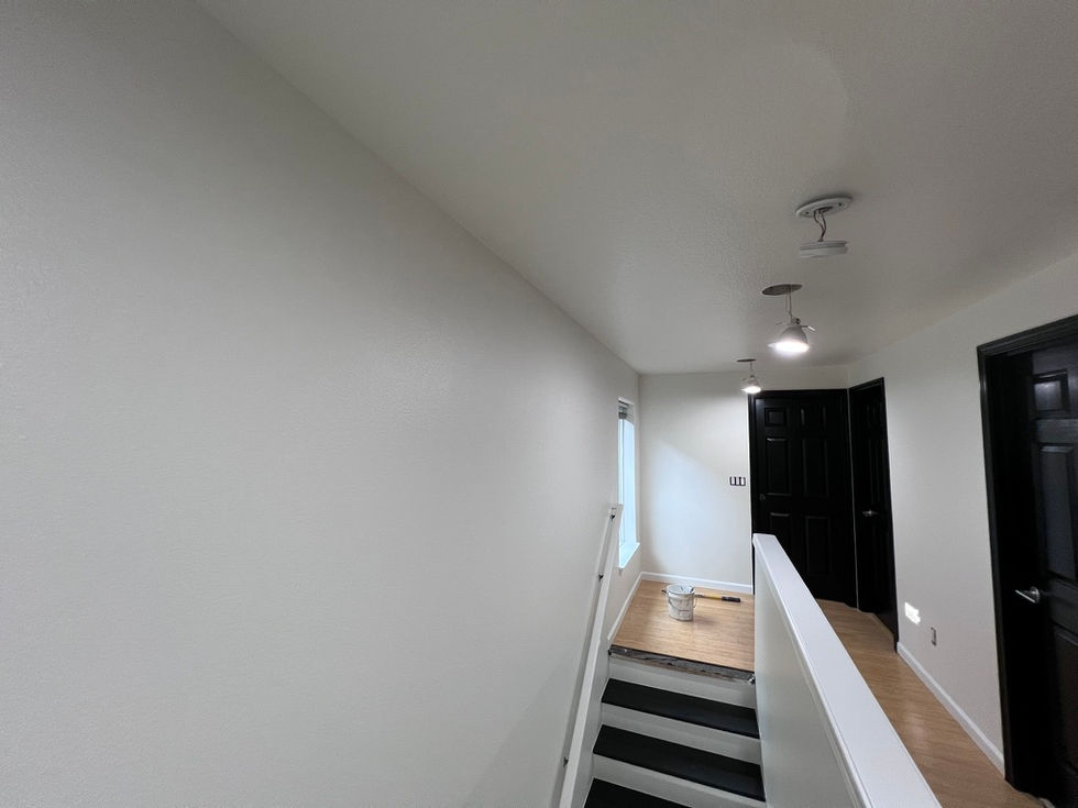 Professional interior painting in Beaverton featuring soft white walls and custom sprayed black interior doors.