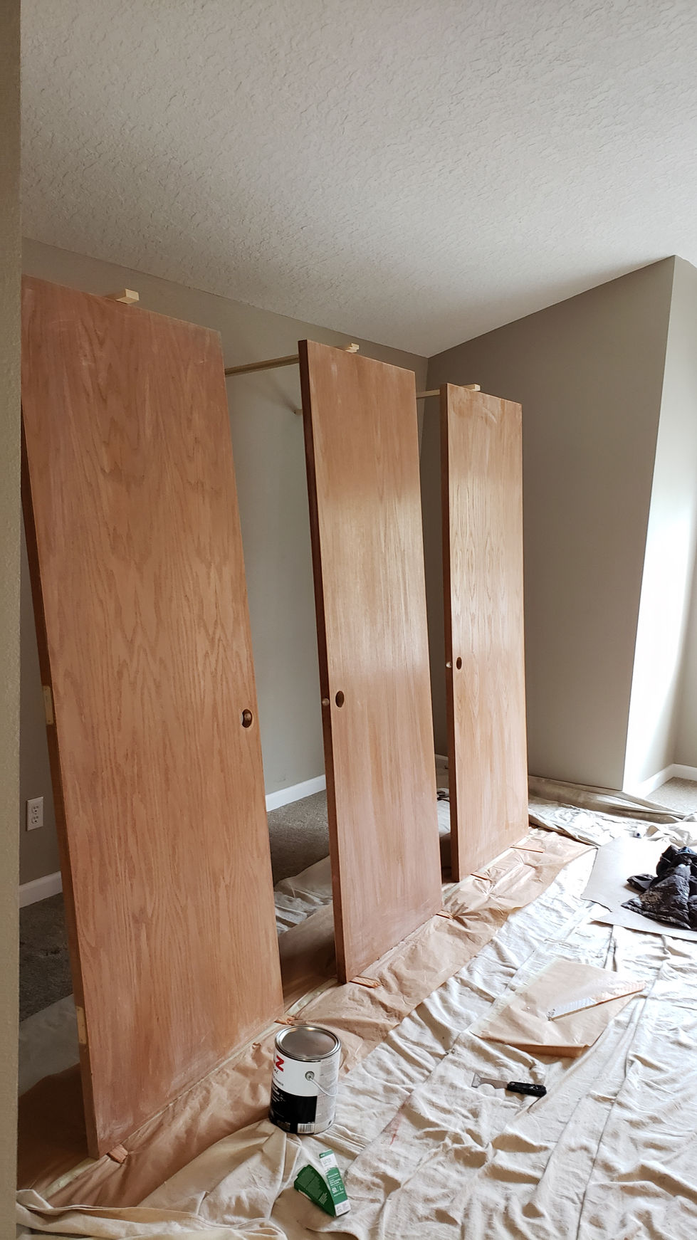 Professional preparation of wood interior doors in a Portland home, featuring sanding and shellac priming to convert stained wood to a modern painted finish.