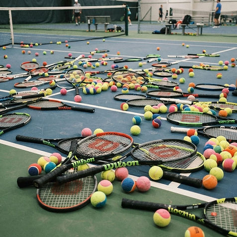 wilson tennis racquets and tennis balls in different colours all over the place.jpg