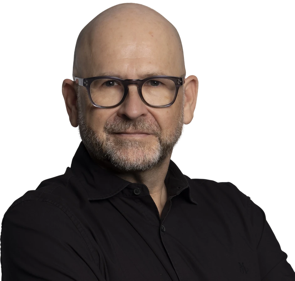 Studio photography of a middle-aged man with glasses and a beard against a black background. He has a professional and confident demeanor.