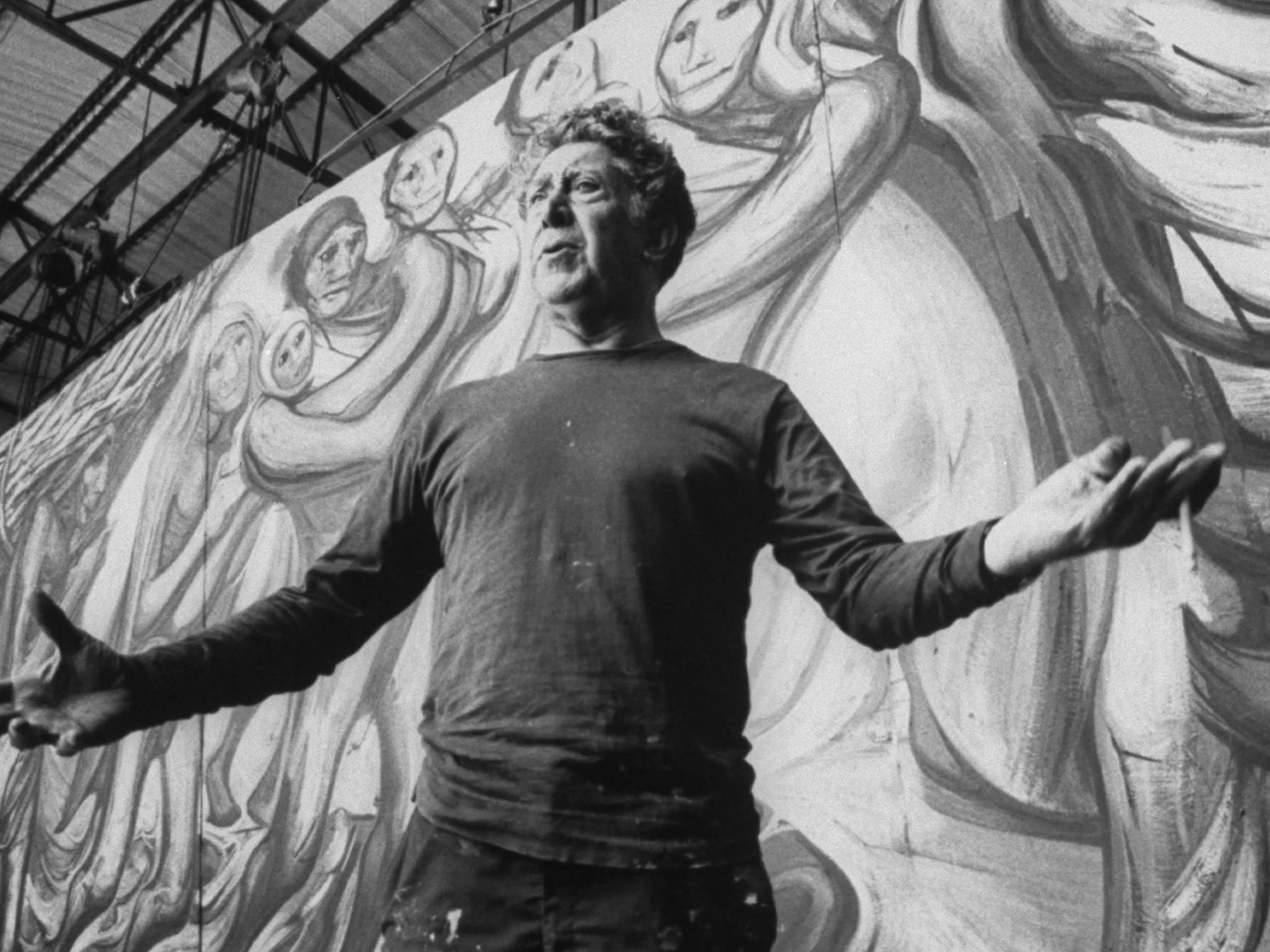 David Alfaro Siqueiros in front of his murals