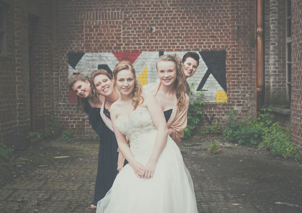 Bruidspaar met vriendinnen graffiti-muur