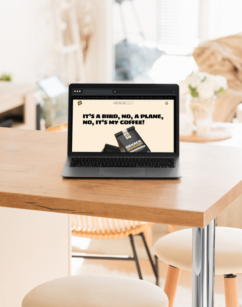 A laptop sitting on a table, displaying Mile High Coffee Club's website landing page.