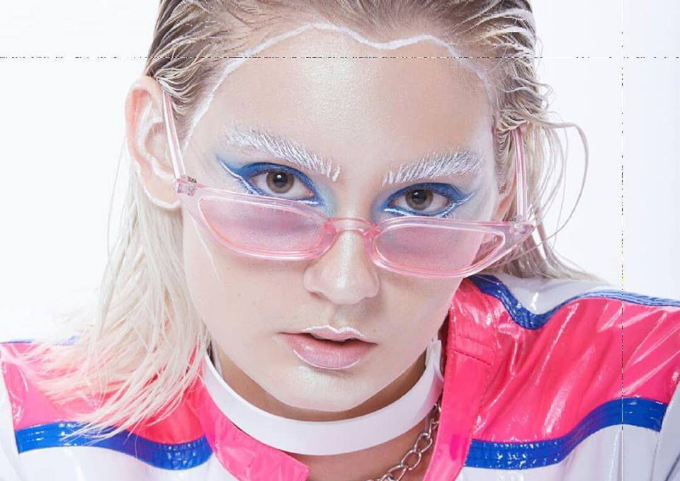DressYourMind Eyewear pink transparent oval framed retro sunglasses on an elegant female fashion model with blonde hairs, premium vintage-inspired eyewear with UV400 lenses