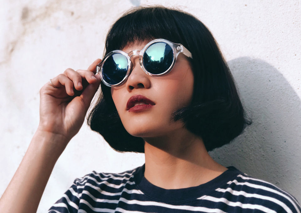 DressYourMind Eyewear white transparent roundframed retro sunglasses on an elegant female fashion model with short dark hairs, premium vintage-inspired eyewear with UV400 lenses