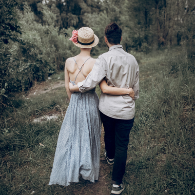 Couple walking arm-in-arm on a rustic path