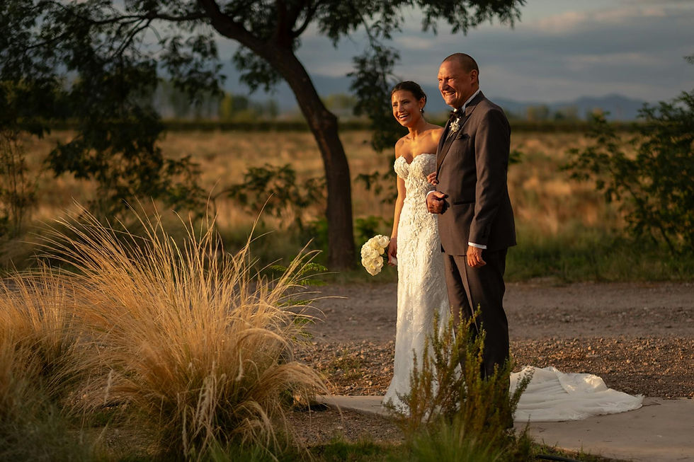 Bride and father walking outdoors in warm light