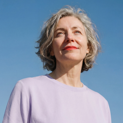 Woman with gray hair looking up at blue sky