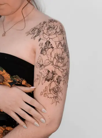 Fine line floral rose and butterfly shoulder sleeve tattoo by Nicolly at The Story of Us MCR, Castlefield Manchester
