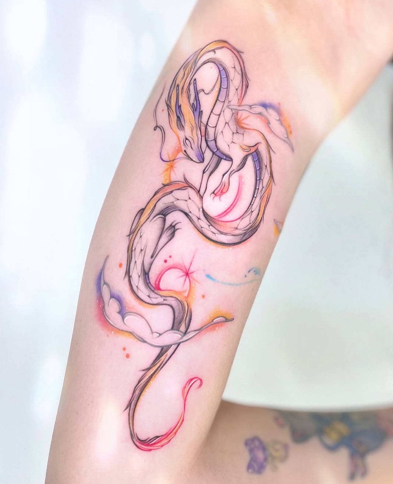Colour fine line fantasy dragon forearm tattoo by Donna at The Story of Us MCR, Castlefield Manchester