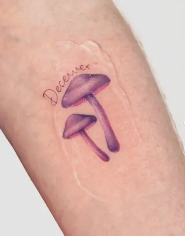 Colour micro realism purple mushroom and script forearm tattoo by Nicolly at The Story of Us MCR, near Deansgate Manchester