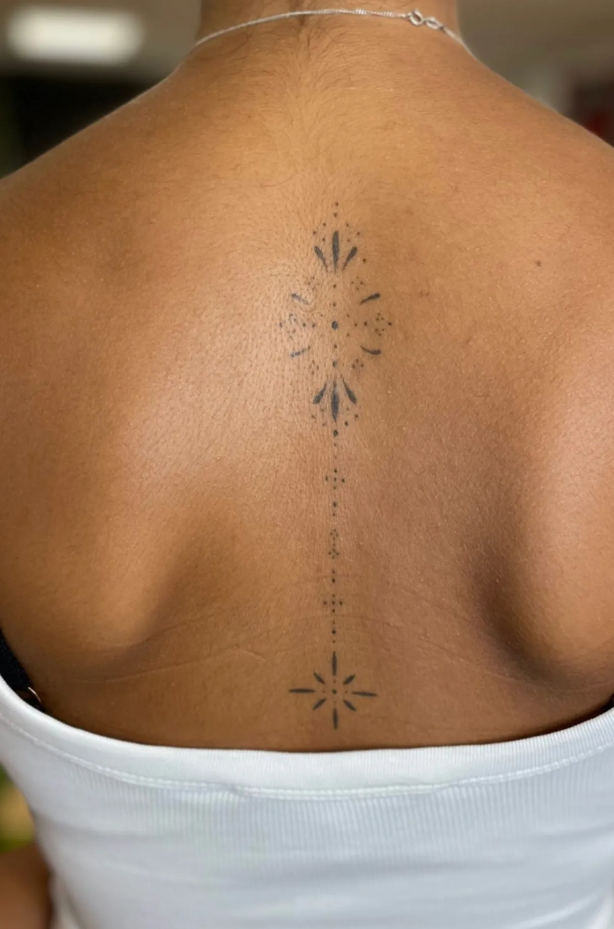 Healed fine line celestial spine tattoo by Anggi
