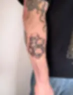 Stacked skulls blackwork forearm tattoo