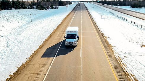Company ambulance driving down a large highway during the afternoon