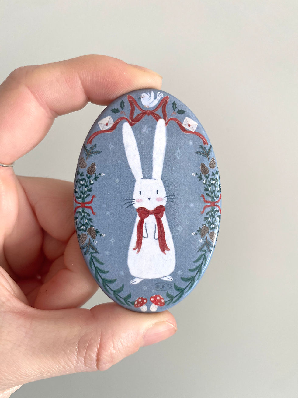 Miniature : Magnet Noël lapin blanc mignon avec nœud sur fond bleu glace et couronne de Noël – magnet métal ovale