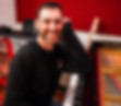 Ross sitting at a grand piano in a music studio