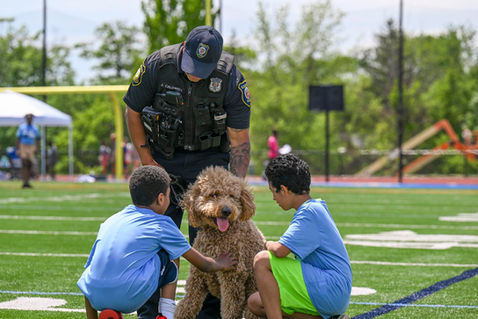 Officer with dog and and kids on field.jpeg