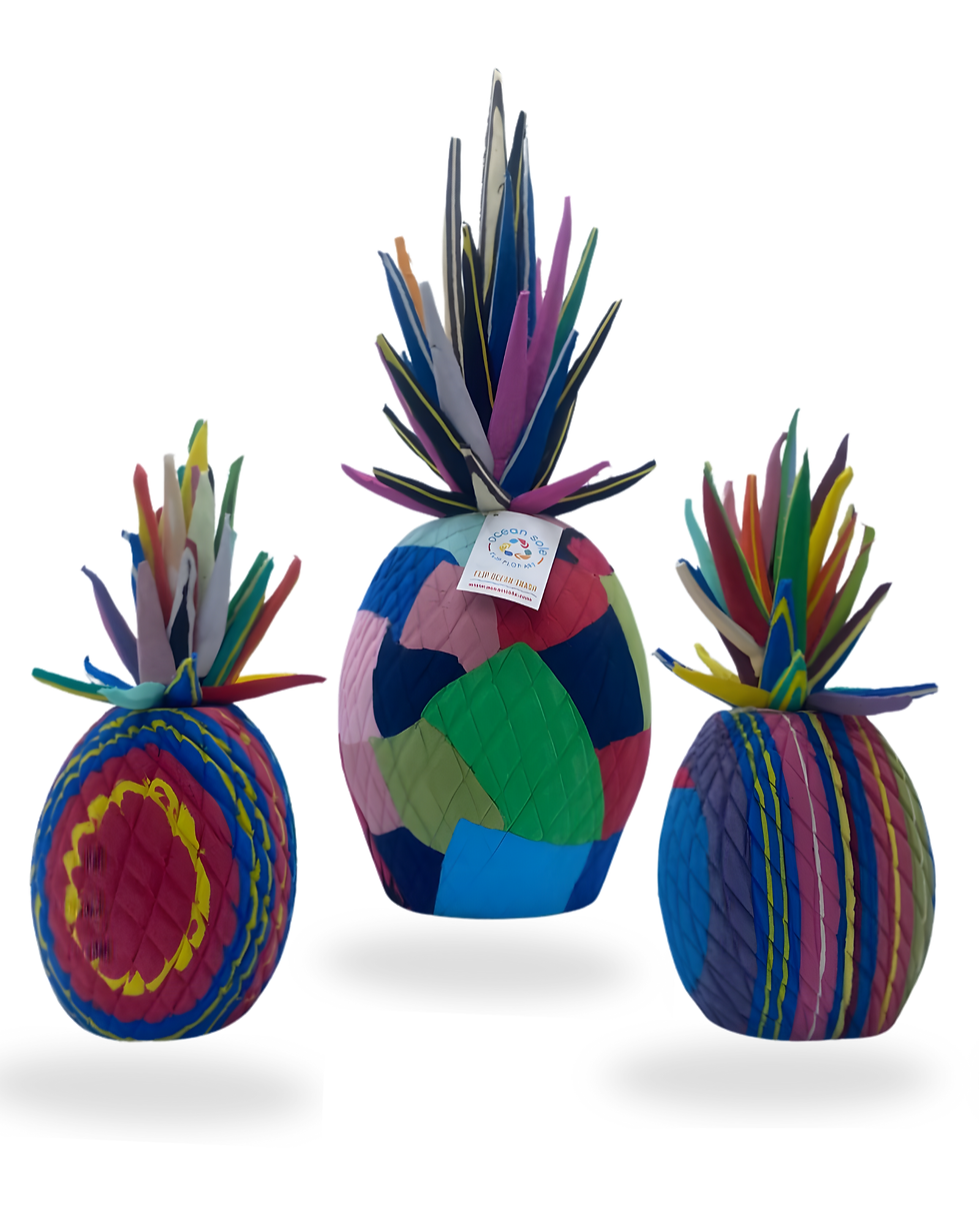 A collection of upcycled flip‑flop pineapples created by Ocean Sole artisan Carol, showcasing her love for bold colours and intricate patterns.