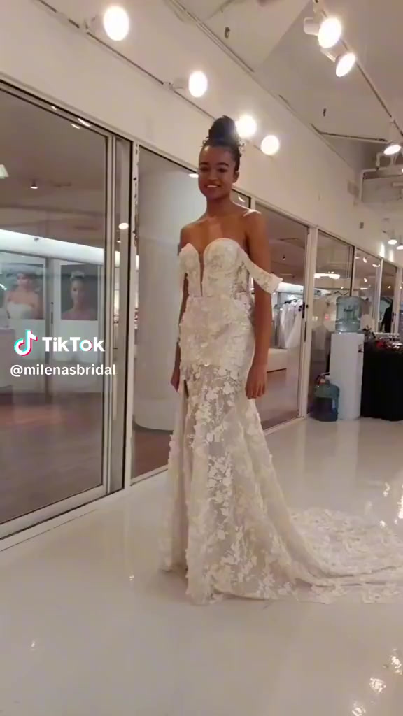 Bride in an off-shoulder lace gown inside the boutique