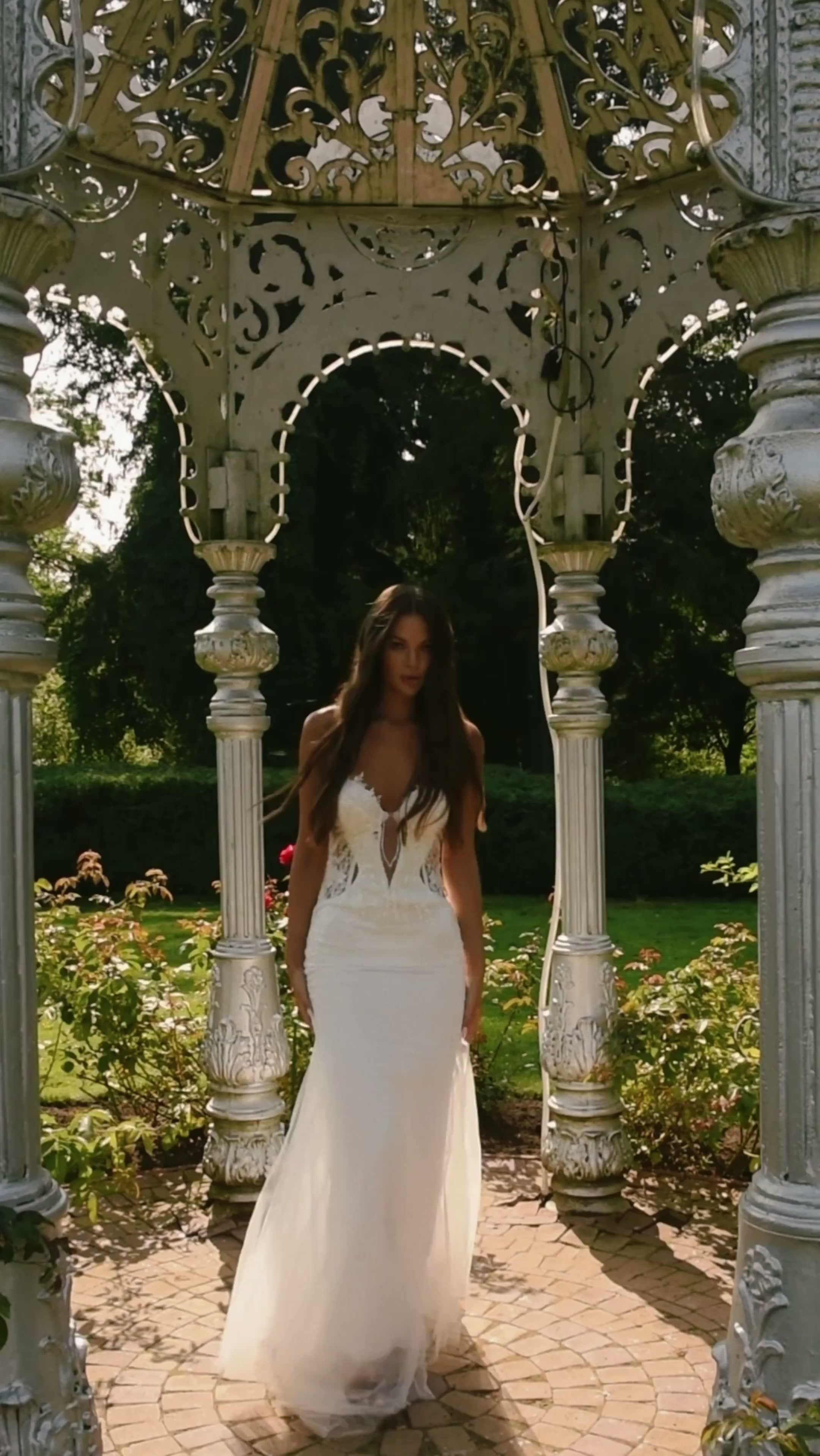 Bride standing beneath an ornate garden arch