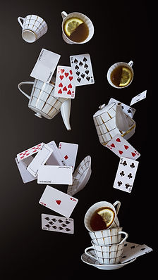 Wonderland background. Mad tea party. Cups, teapot and playing cards falling down the rabbit hole
