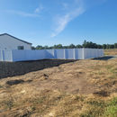 White vinyl fence from a distance on a newly built home with no landscaping. Installed in Roseville by Fence Lifts