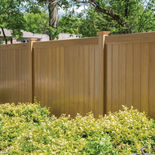 6 feet tall brown colored vinyl fence with mid height shrubs along the fence. Built by Fence Lifts in Auburn.