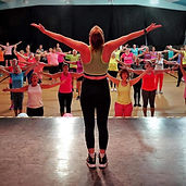 Instructor on stage in front of keep fit class
