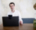 Sebastian Stiewe sitzt vor einem Laptop und sc