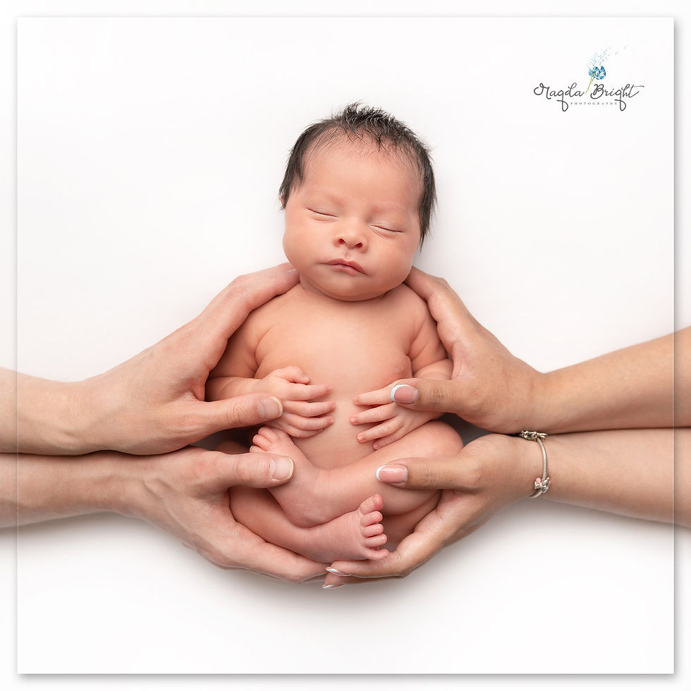 Family and newborn photography Surrey – parents cuddling their newborn baby in studio, safe in parents' hands