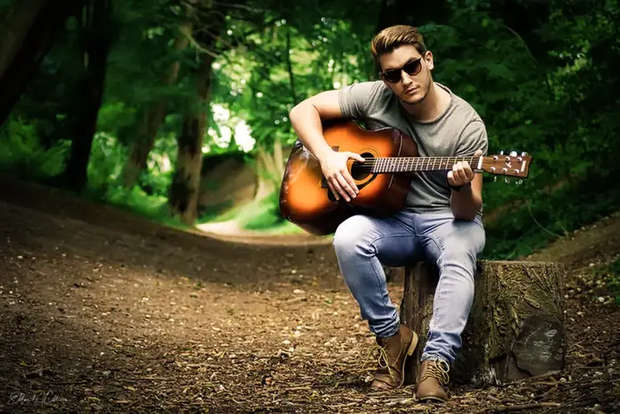 Home photographer - A natural light portrait of a man playing the guitar in a woodland setting