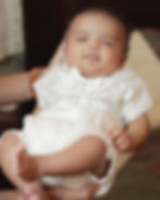 Baby in a white christening outfit, photography portfolio.