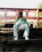 Man in a green jersey sitting on stone steps in a photography portfolio