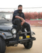 Man sitting on a black jeep for a photography portfolio